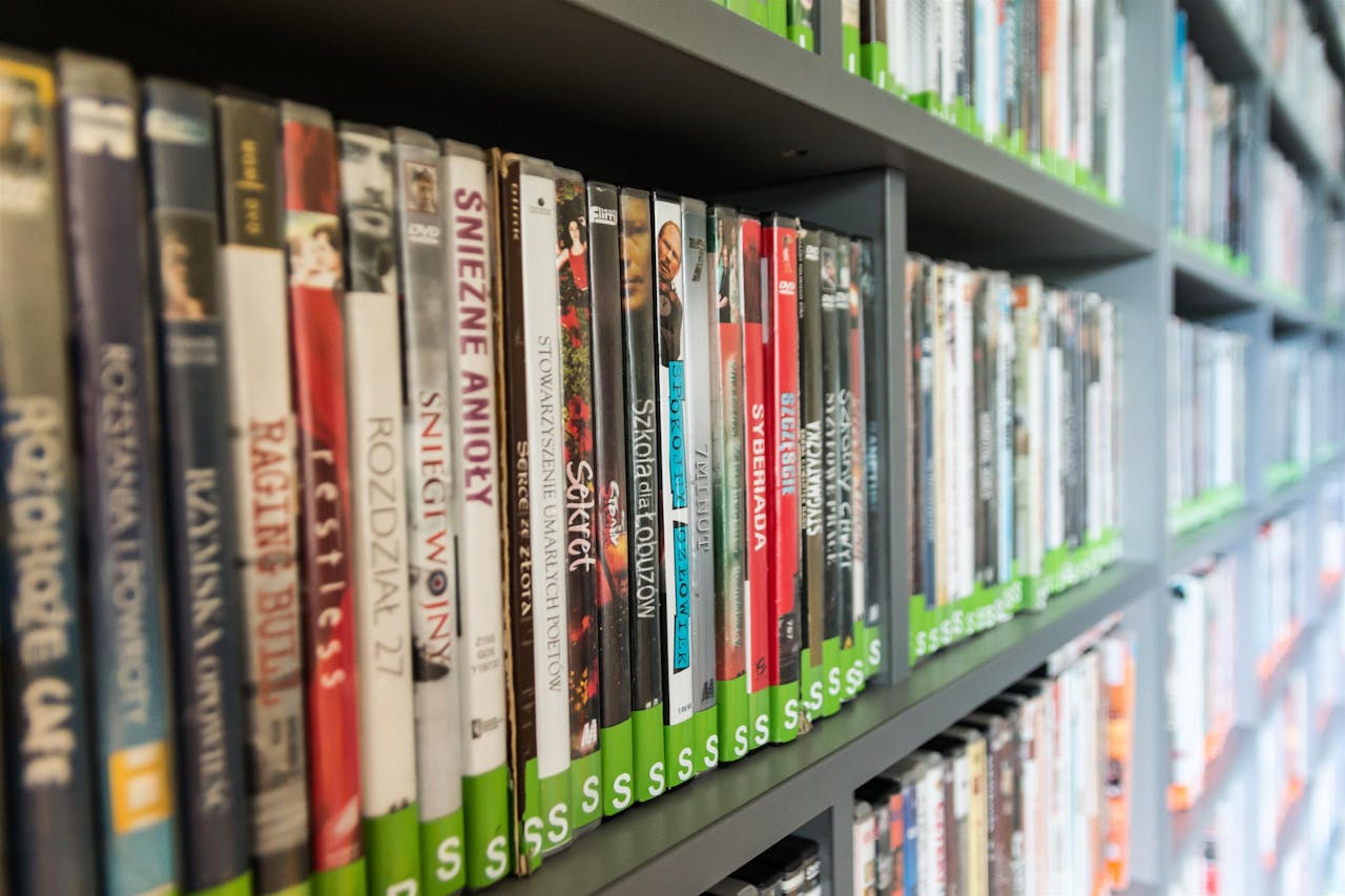 Close-up of a library shelf filled with DVDs showcasing various titles and colors.